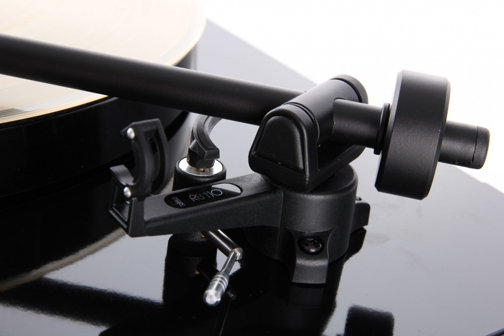 En skivspelare med tonarm och skivtallrik. Enkel och stilren design.