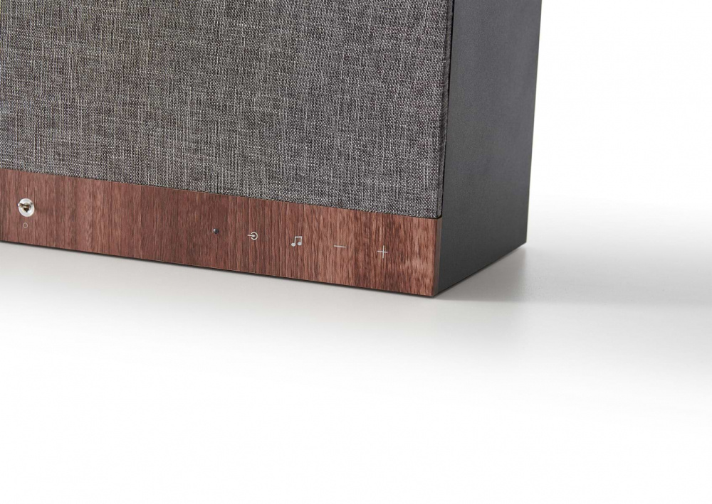 En kvadratisk Bluetooth-högtalare med textilfront och trädekor.