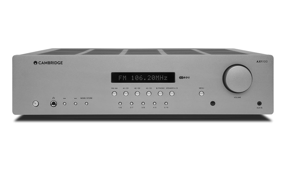 Stereoreceiver med FM-radio och DAC, silverfärgad med knappar och volymkontroll.