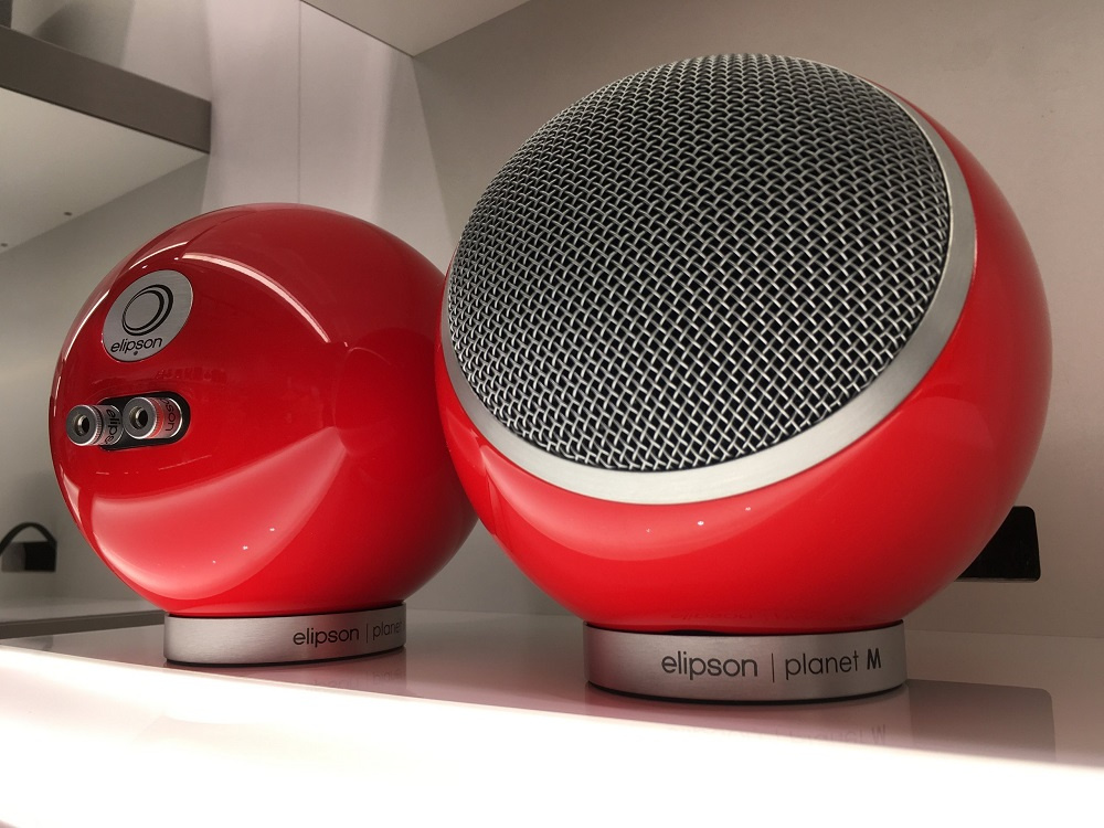 Röda, runda högtalare med nätgaller, designade av Elipson.