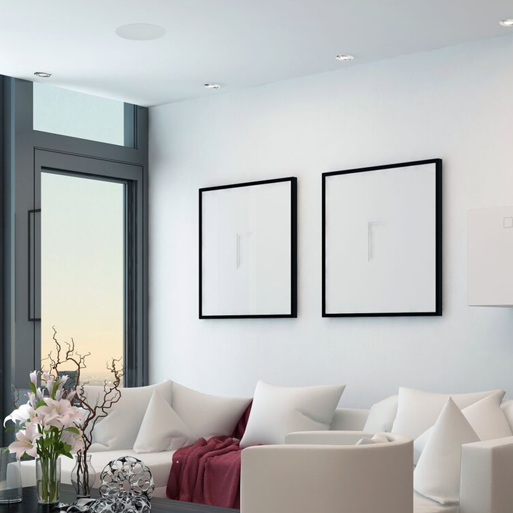 Modernt rum med ljusa väggar, soffor och takmonterade högtalare.