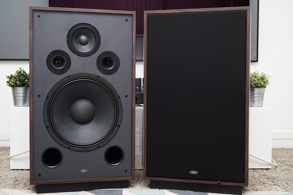 Två väggmonterade golvhögtalare i valnöt med svart front.