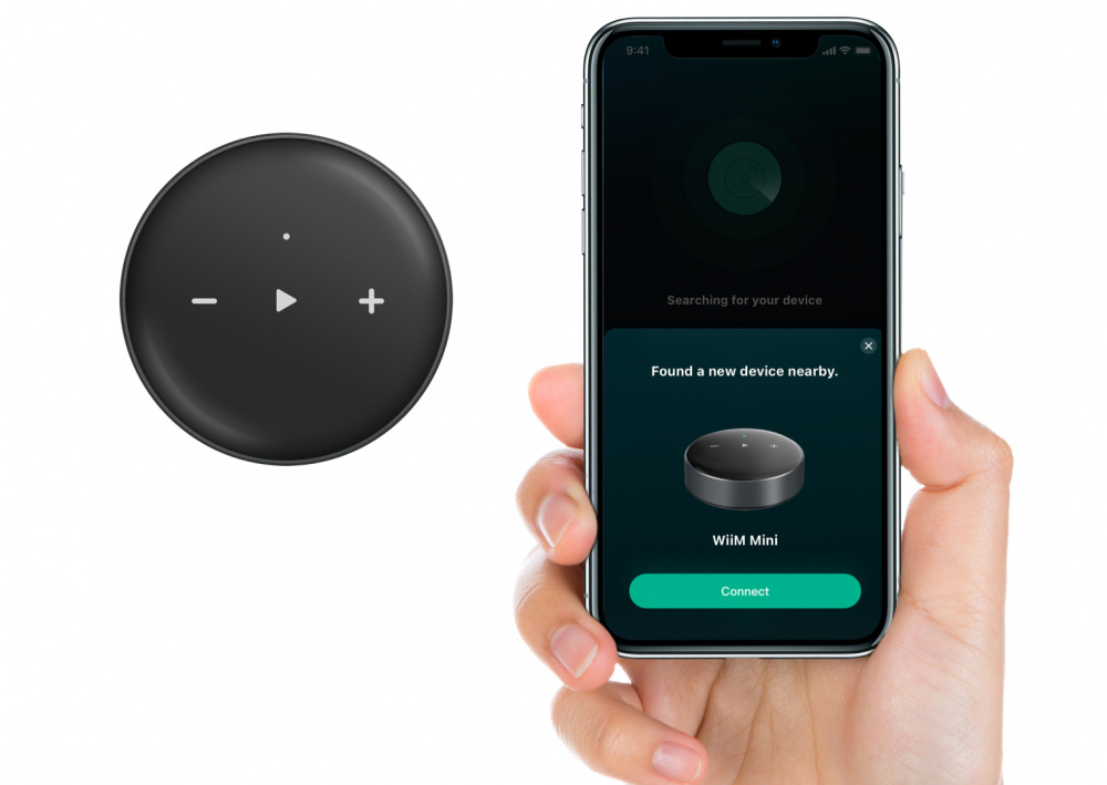 En hand håller en smartphone som visar en kopplingsskärm för WiiM Mini.
