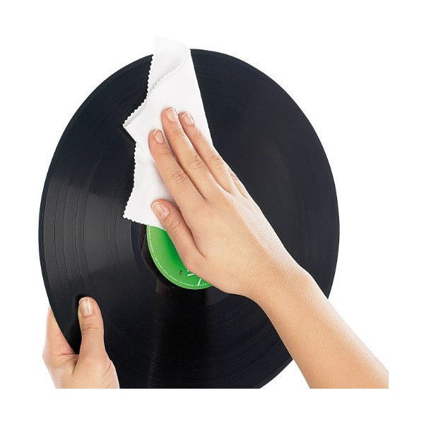 En hand rengör en vinylskiva med en vit trasa.