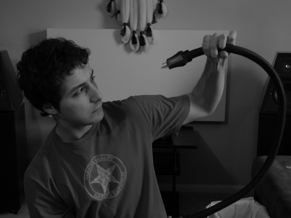 En man håller i en elkabel med en kontakt.