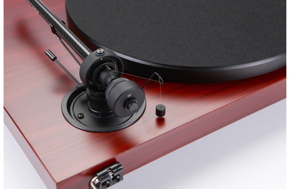 En skivspelare med ädelträ finish och svart matta.