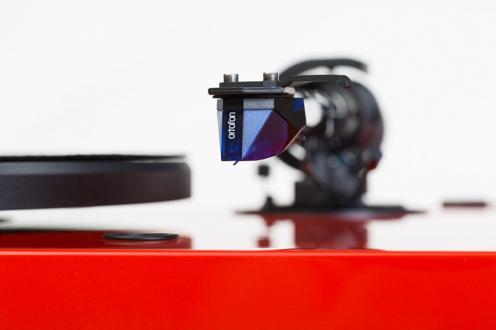 Skivspelare med röd finish och Ortofon 2M Blue-pickup.