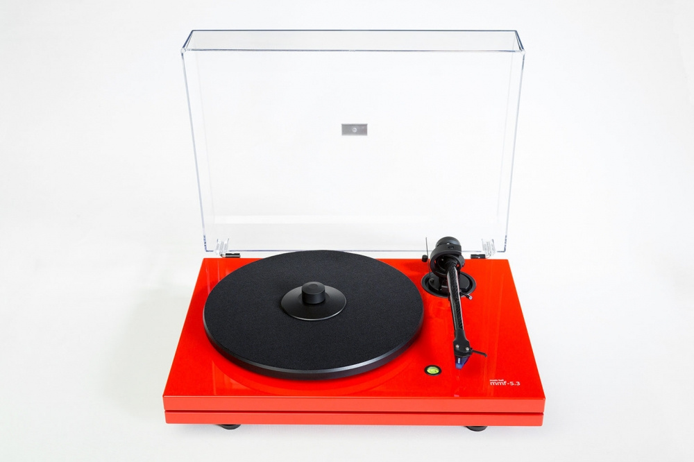 En röd skivspelare med genomskinligt lock och svart skivtallrik.