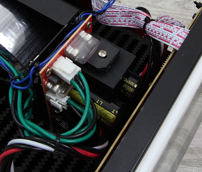 Inuti ett elektroniskt enhet med färgglada kablar och komponenter.