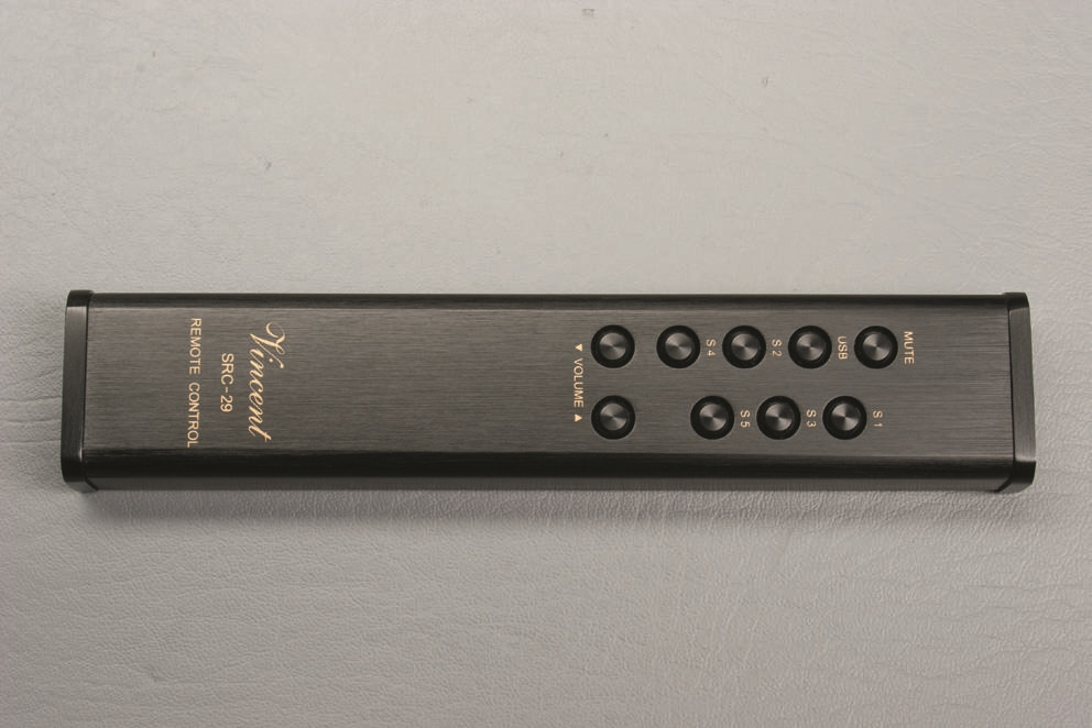 En svart fjärrkontroll med knappar för volym och funktioner.