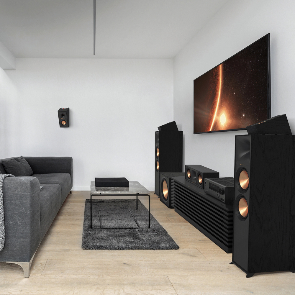 Modernt vardagsrum med tv, högtalare och minimalistisk inredning.