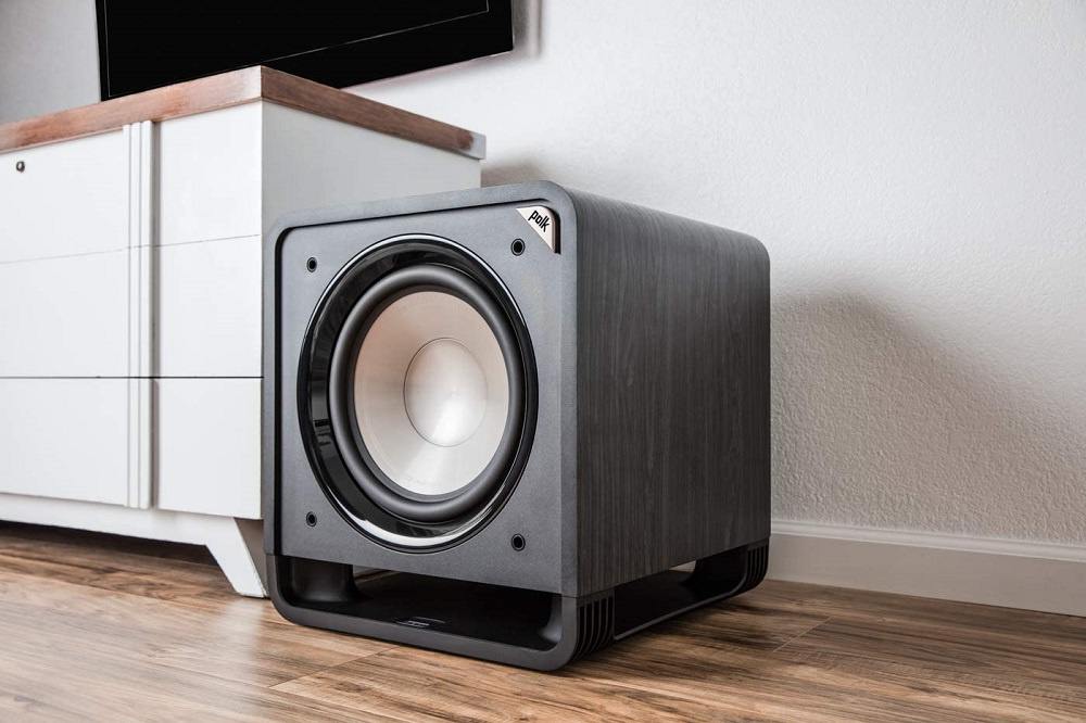 Aktiv subwoofer i svart, med rund högtalare och modern design.