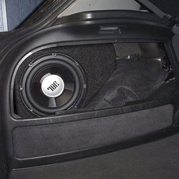 En baslåda med en stor högtalare inuti en bils bagageutrymme.