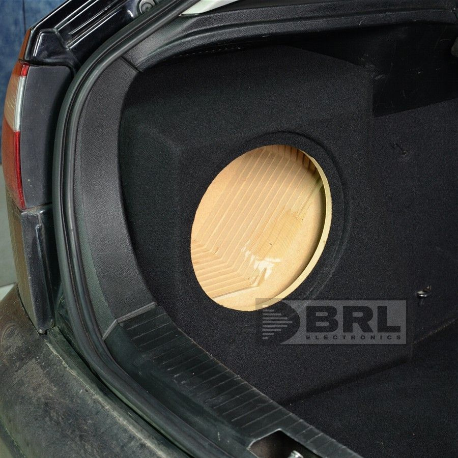 Bilden visar en baslåda för en bil med rund öppning, installerad i bagageutrymmet.