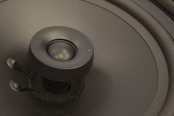 En mörk inbyggnadshögtalare med en central diskant.