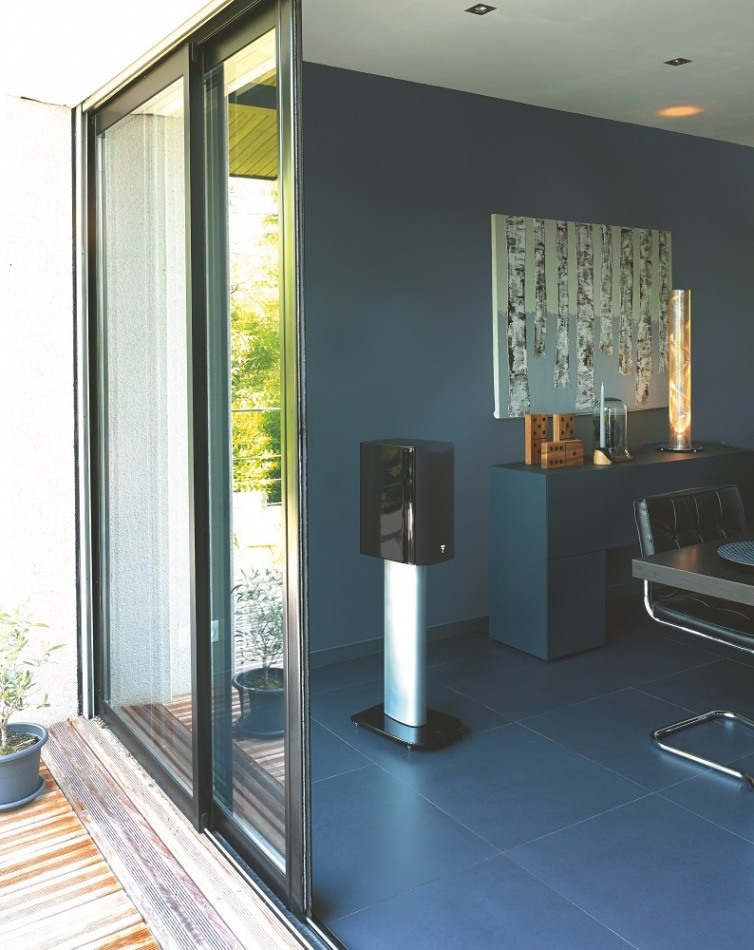 Stativhögtalare i modern inredning med stora fönster och stilren decor.