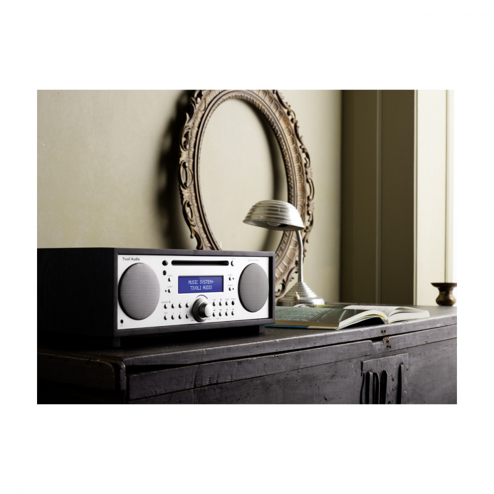 En elegant ljudanläggning på en möbel med en lampa och en spegel i bakgrunden.