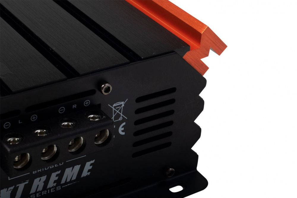 En del av en svart förstärkare med orange detaljer och anslutningar på baksidan.