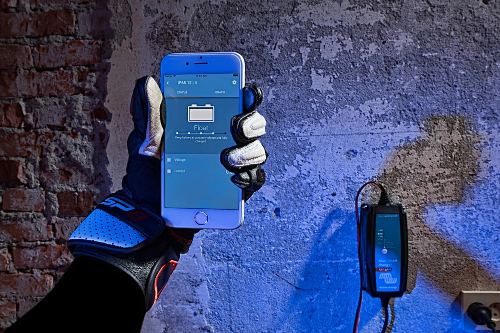 En hand med en telefon som visar information om en batteriladdare.