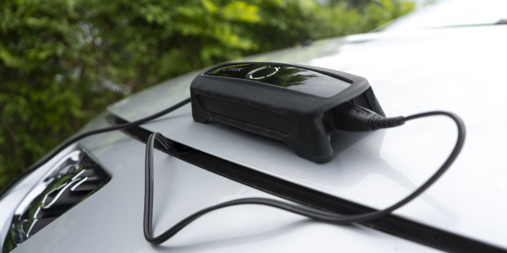 Laddare med skyddande bumperskydd på en bil.