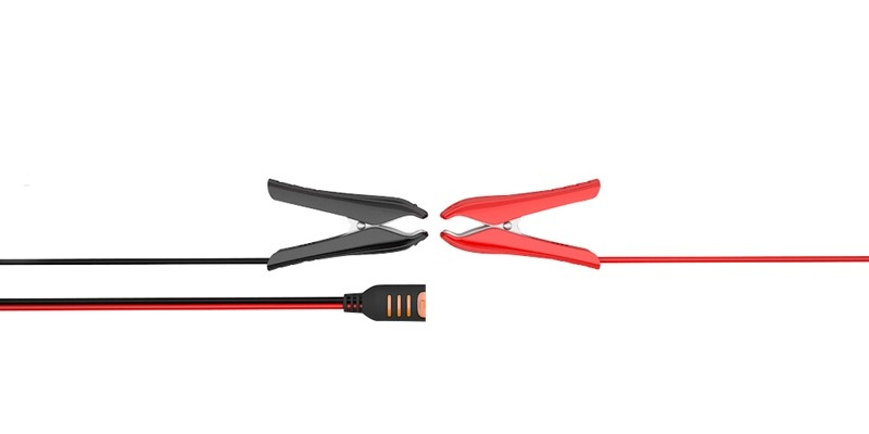 Svarta och röda klämmor på kabel för anslutning till batteri.