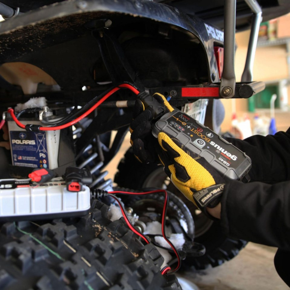 En person kopplar starthjälp till en motor med en NOCO GBC007-kontakt.