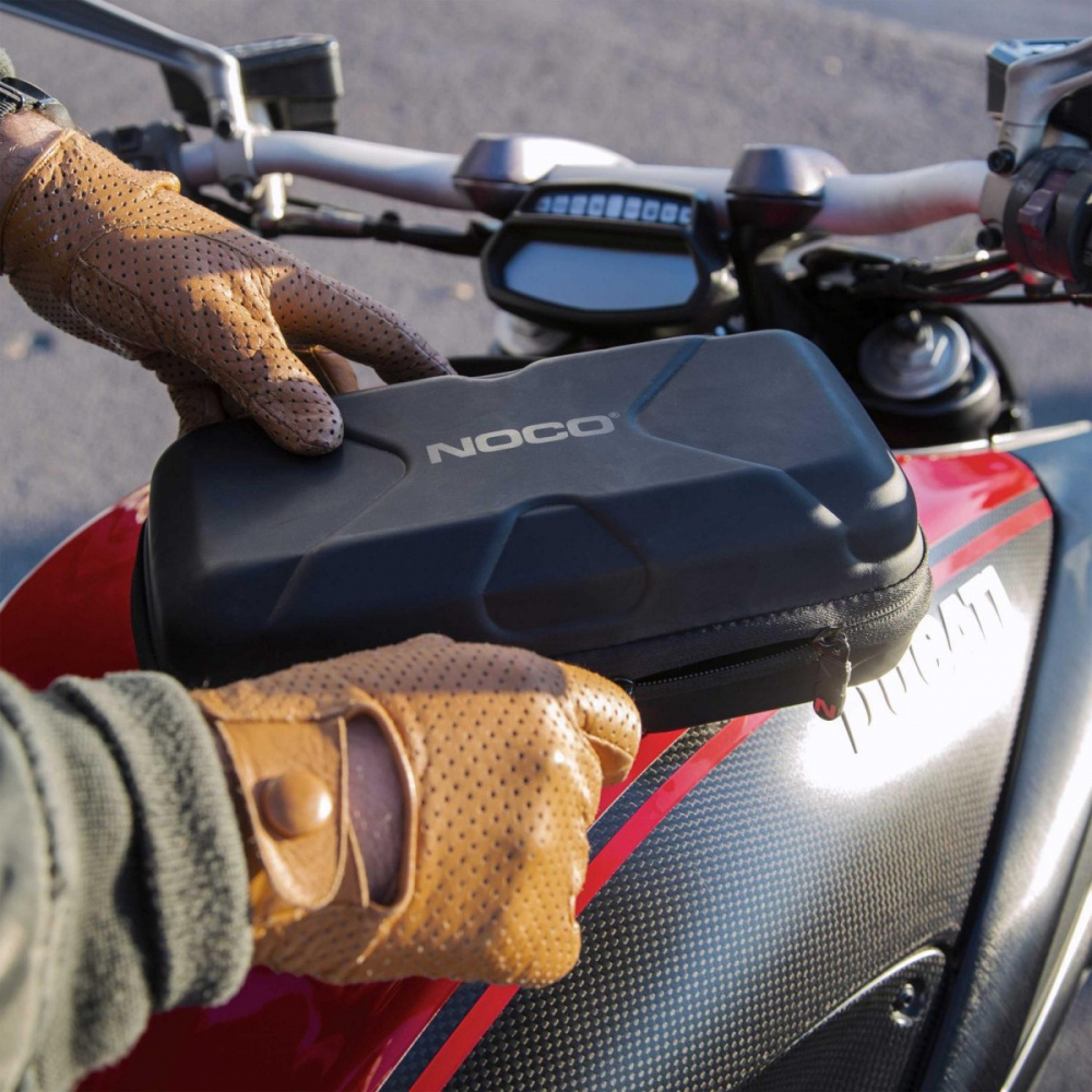 En svart förvaringsväska med NOCO-logga på en motorcykel.