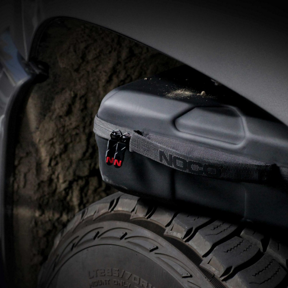 En svart förvaringsväska med dragkedja, placerad på en bils baksida.