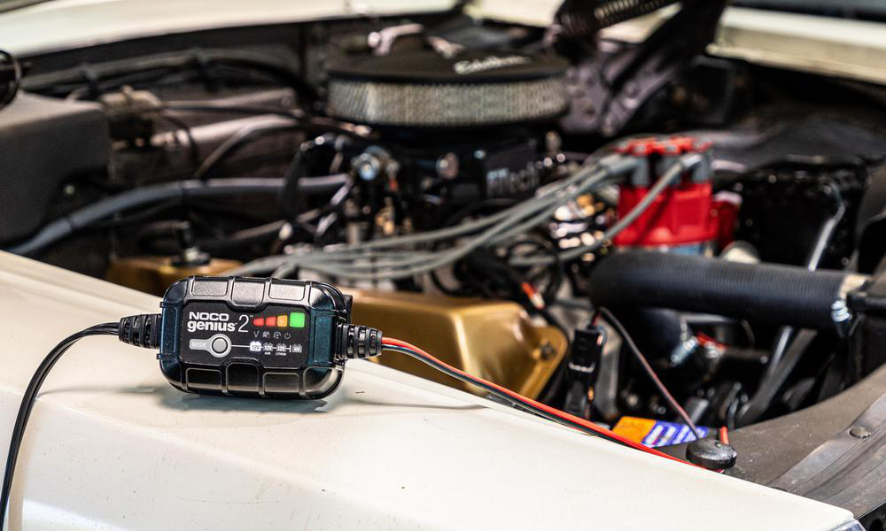 En NOCO Genius 2 batteriladdare kopplad i en bilmotor.