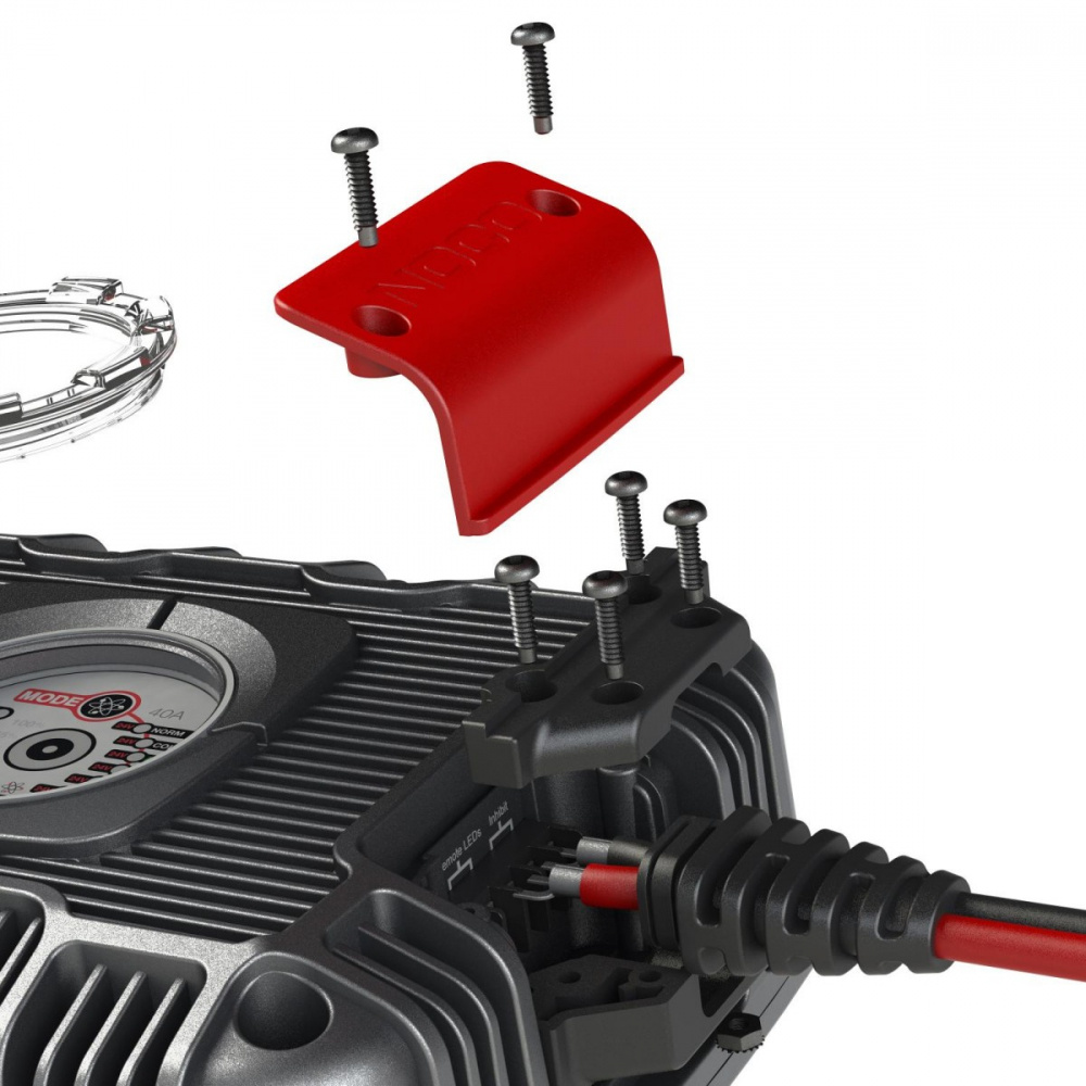 En del av en motor, skruvar och en röd skyddskåpa i detalj.