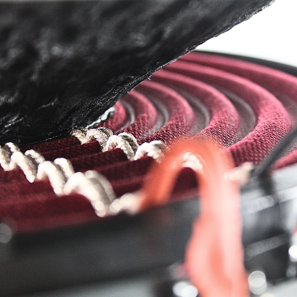 Baselement med svart kon och röd upphängning i detalj.