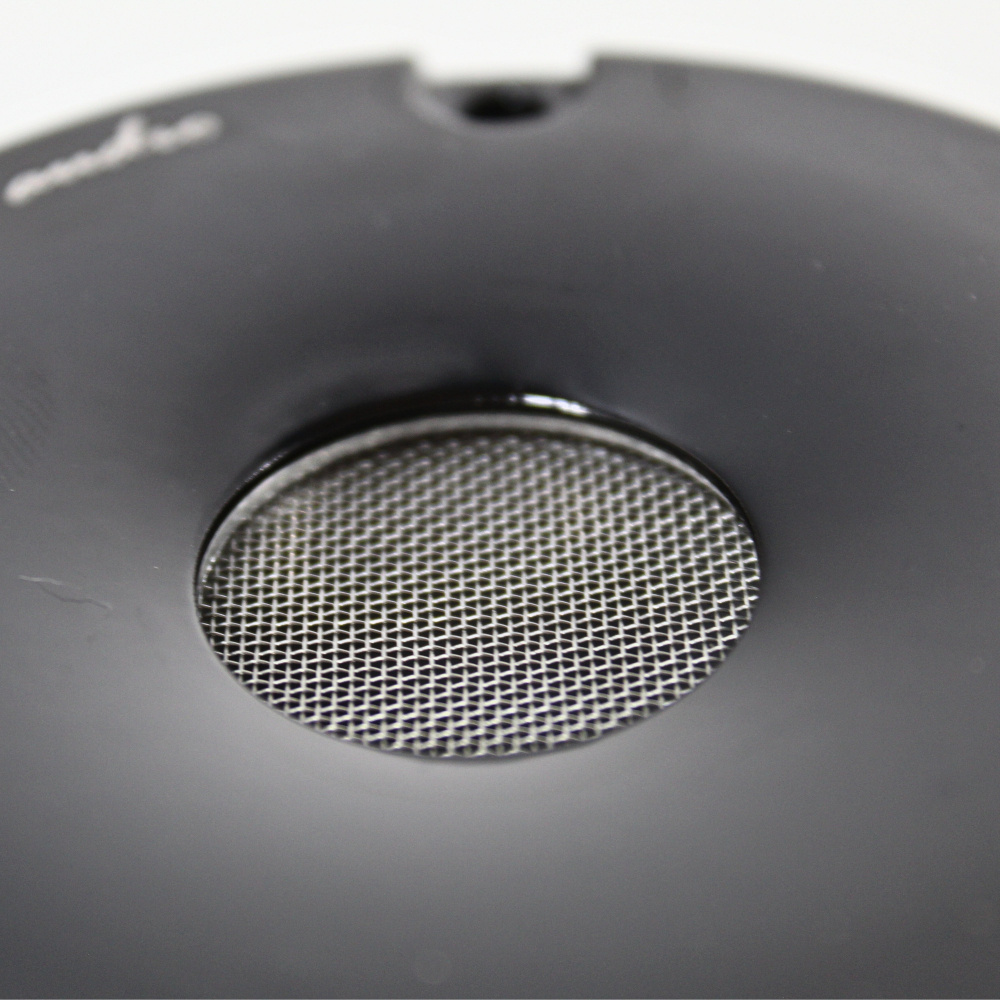 Svart horndiskant med metallisk galler för ljudåtergivning.
