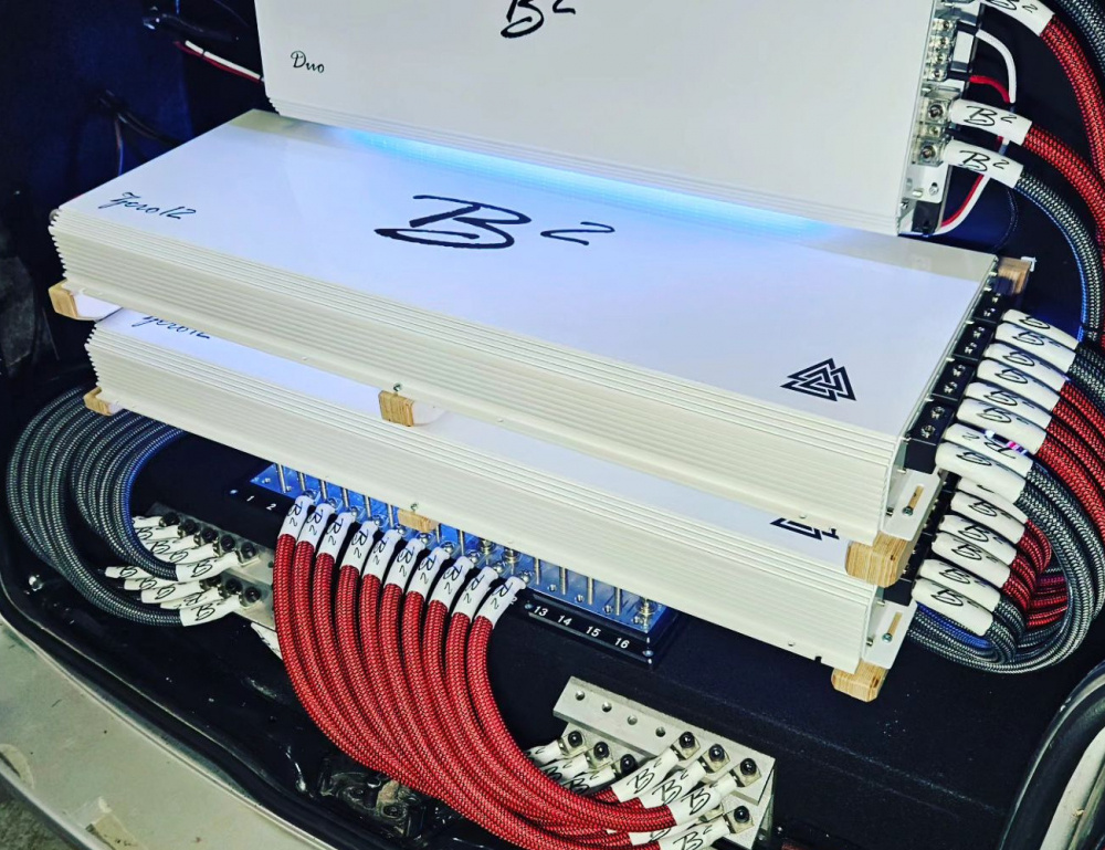 Flera förstärkare och anslutningar för ljudsystem i en bil.