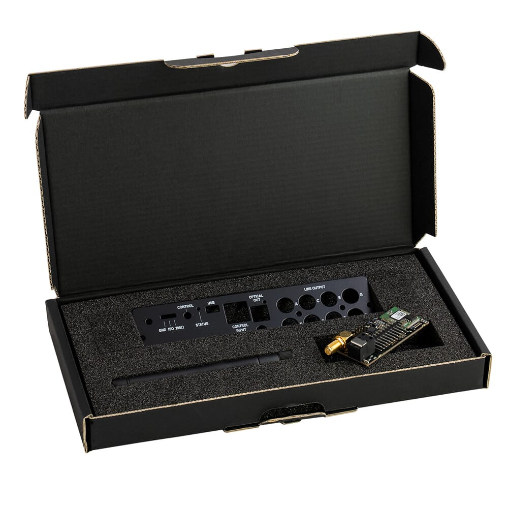 Ett öppet paket med en elektronisk enhet och tillbehör i skumgummi.