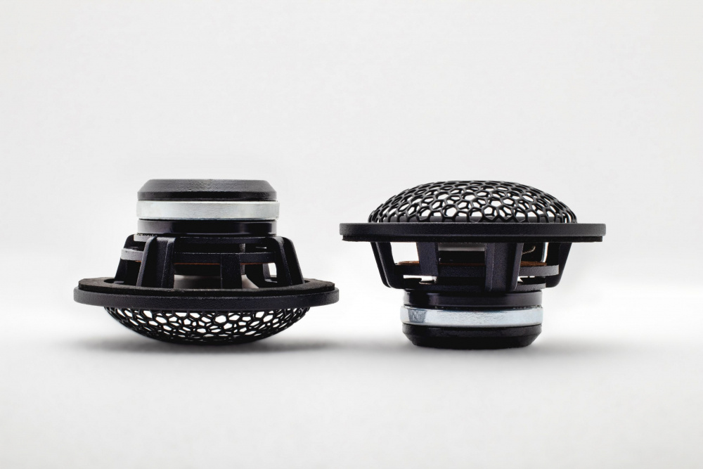 Två högtalarelement med nätkåpor, designade för ljudprestanda.