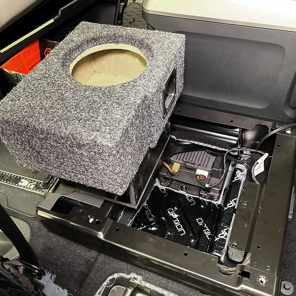 En tom baslåda med ljudsystem i en bilinteriör.