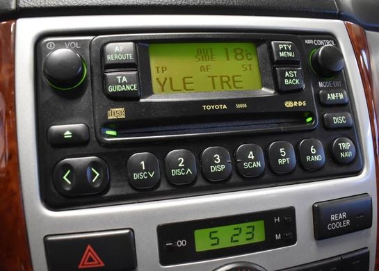 Bild på en bilstereo med olika kontroller och display.