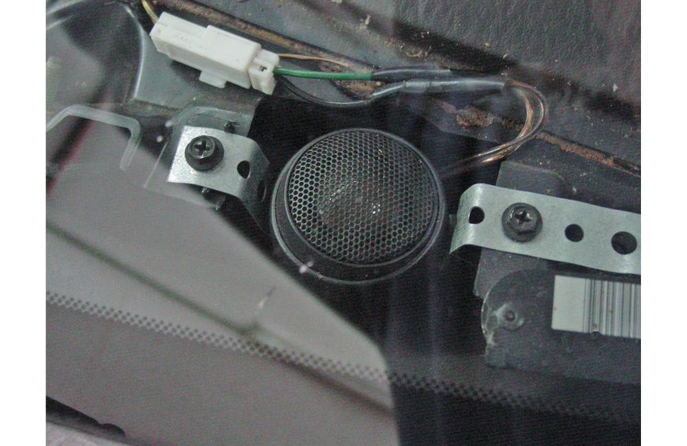 En närbild av en högtalare med metalldelar och kablar.