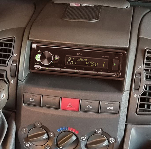 En bilstereo installerad i en bilpanel med kontroller.