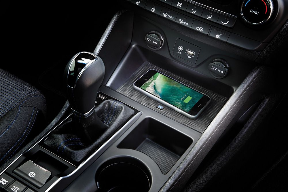 Qi-laddare i en bil, smartphone på laddningsytan i mittkonsolen.