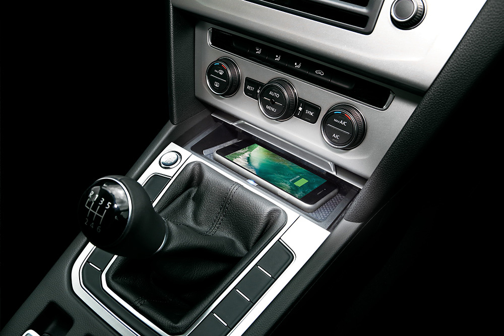 En Qi-laddare installerad i en Volkswagen Passat med en smartphone på.