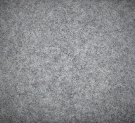 Grå högtalarmatta med en textur av filtliknande material.