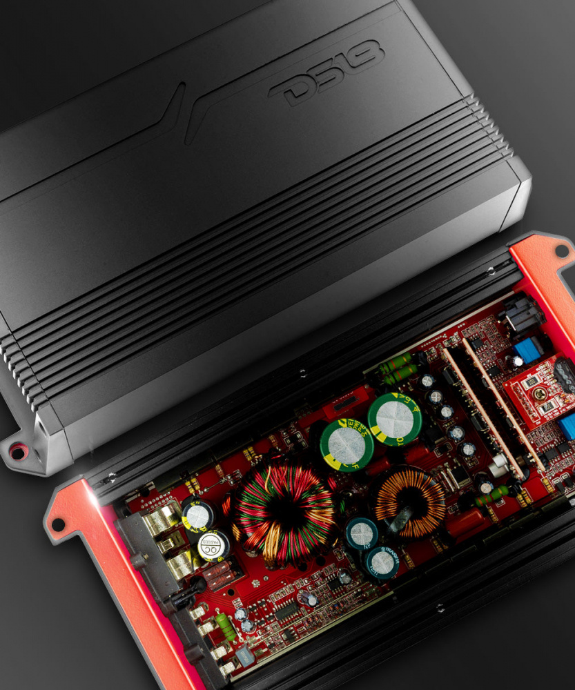 En svart monoblock förstärkare med röd insida och elektroniska komponenter.