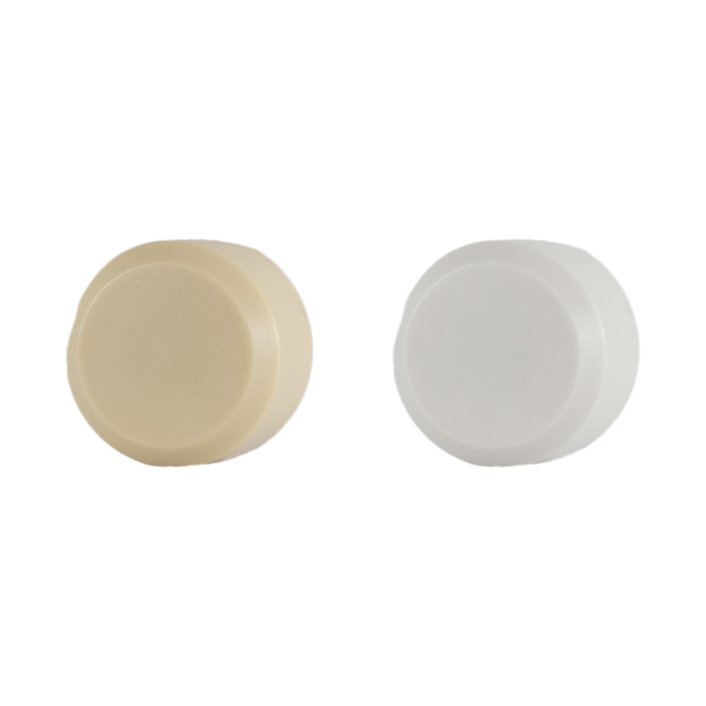 Två rundade volymkontroller, en beige och en vit.