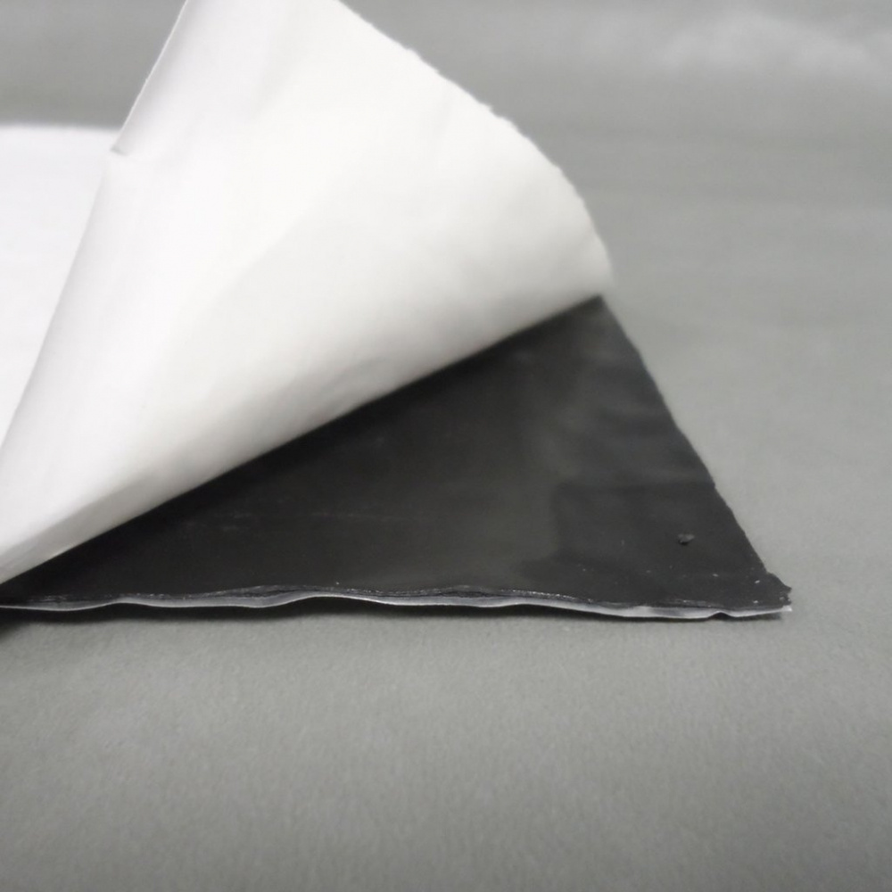 En svart, 2 mm tjock vibrationsdämpande matta med skyddande överdrag.