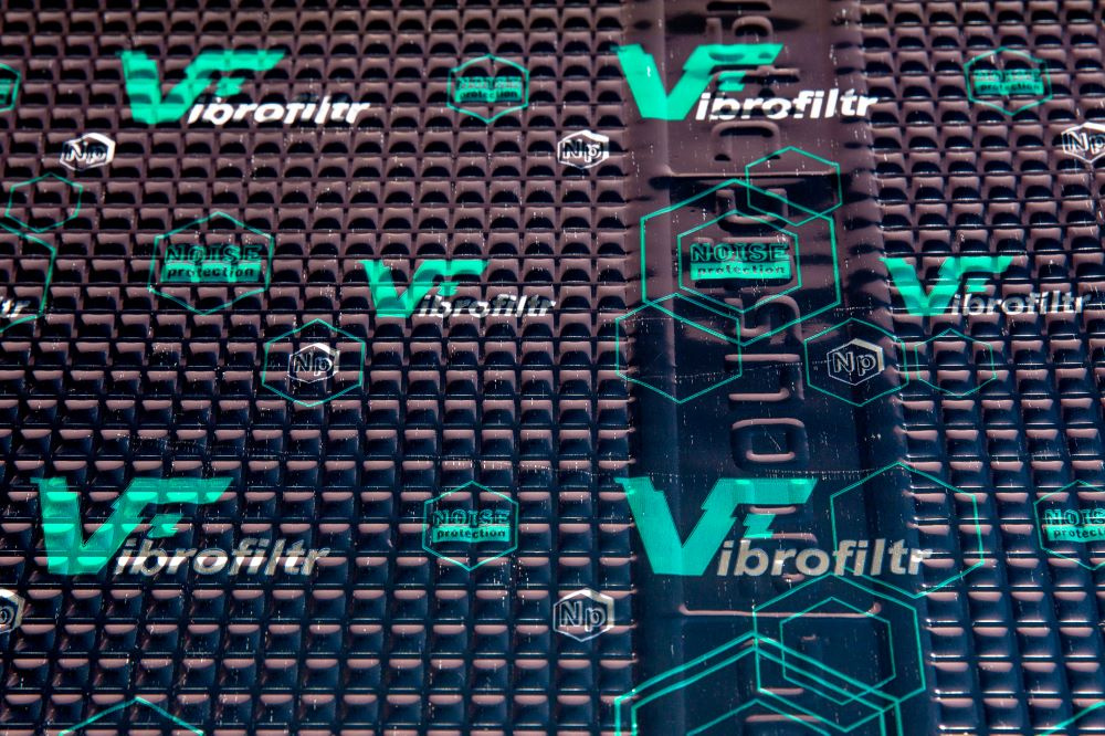 Svart dämpmatta med gröna mönster och logotyper för Vibrofiltr.