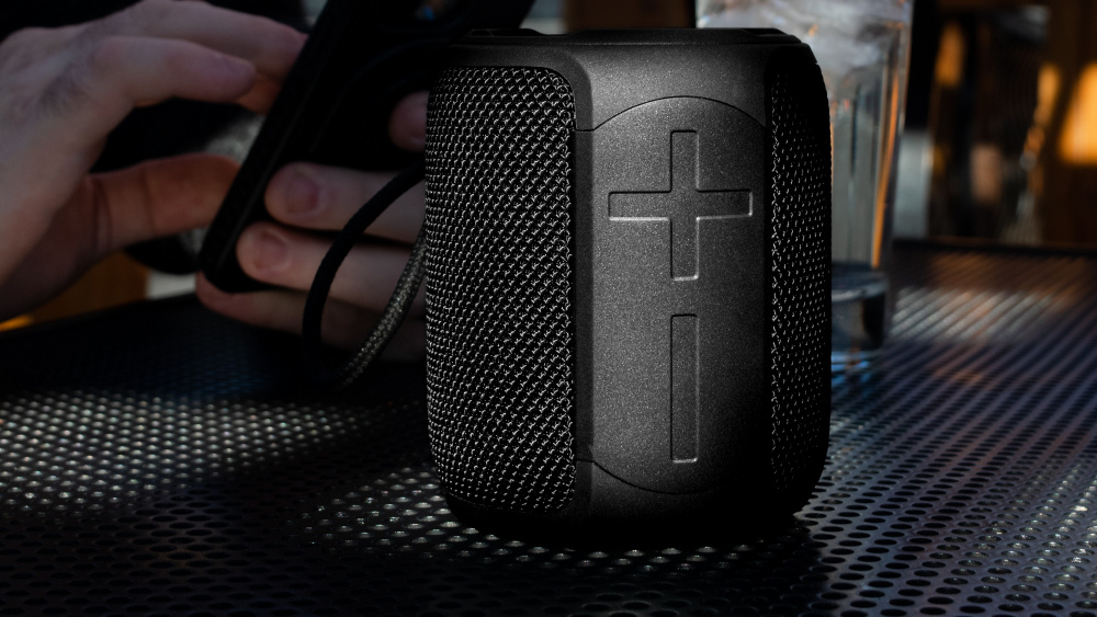 Portabel Bluetooth-högtalare med svart design och texturerad yta.