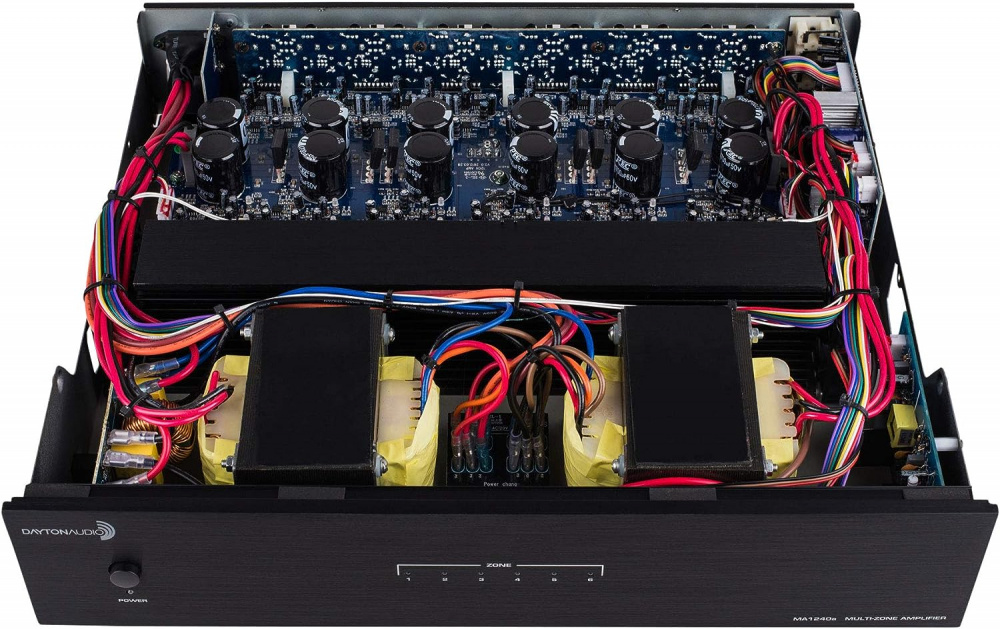 Multiroomförstärkare med synliga komponenter och kablar inuti en metallkapsling.