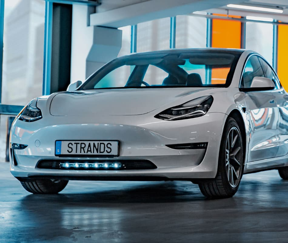 En vit bil med en LED-ramp installerad under fronten.