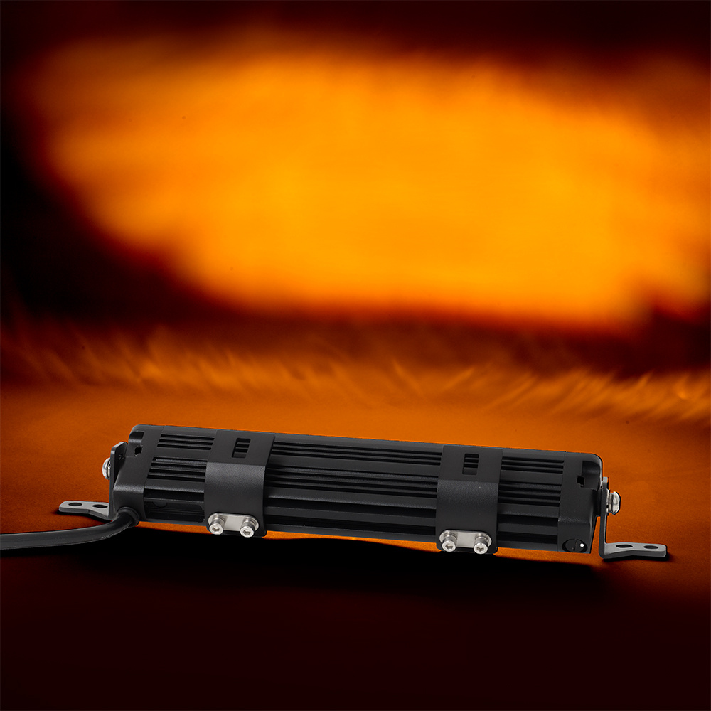 En svart LED-ramp med synliga monteringsfästen på en orange bakgrund.